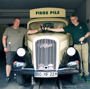 Zwei Männer vor Siege Pils Auto